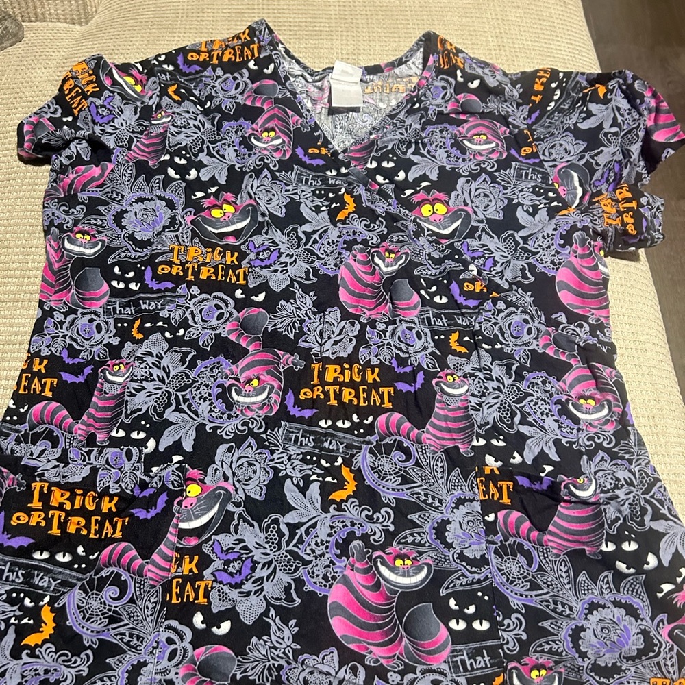 Disney Cheshire Cat Halloween scrub top in Black, Purple, Pink and Yellow